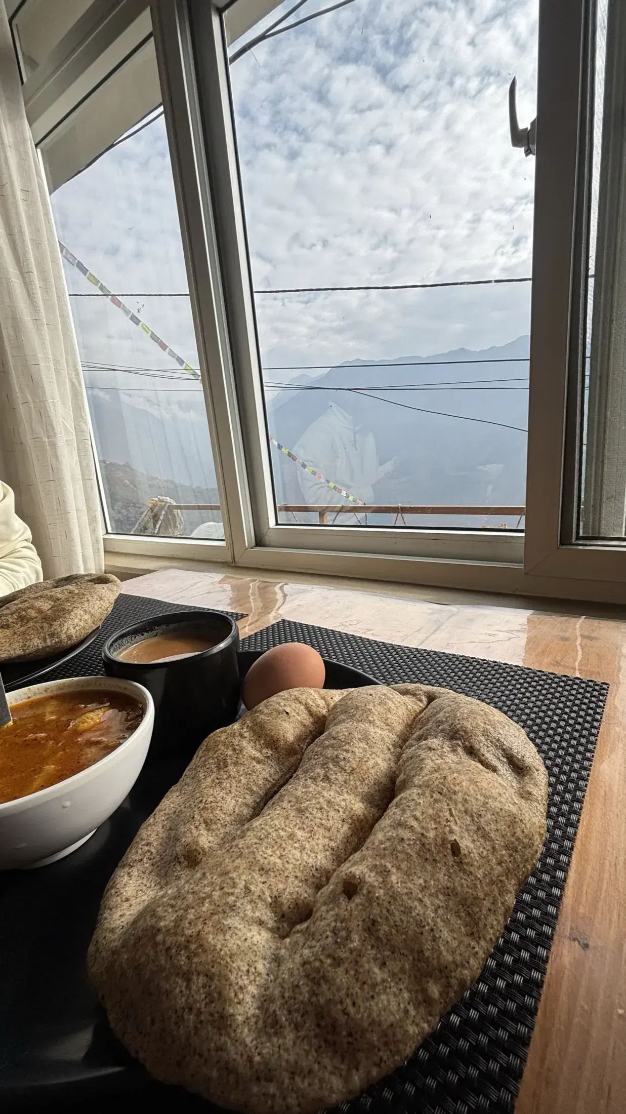 Breakfast served beside a window overlooking the mountains in Ghandruk