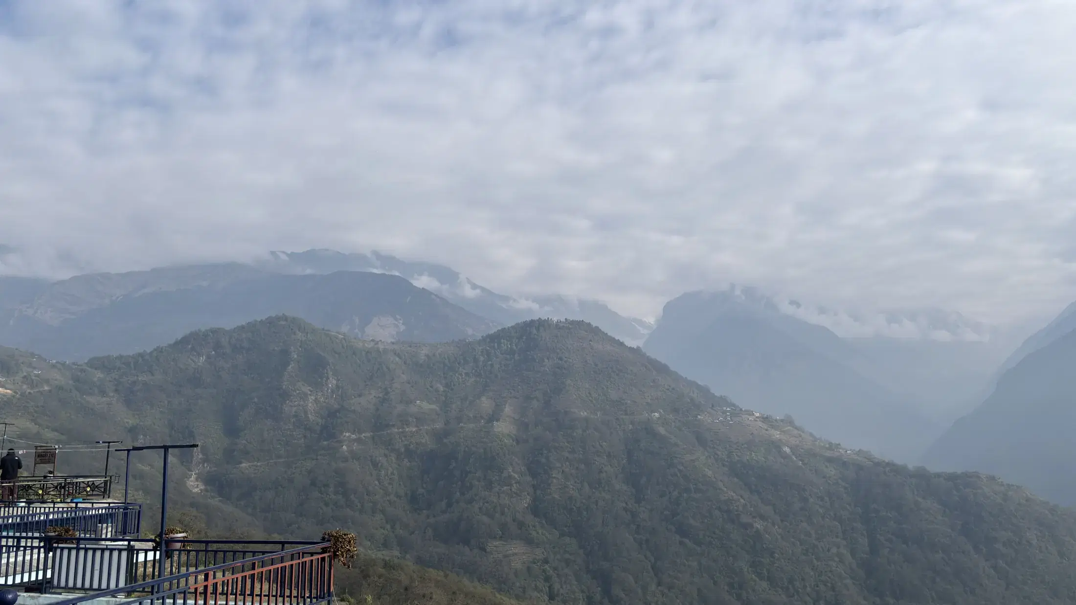 Layered green mountain ridges and low clouds viewed from Ghandruk