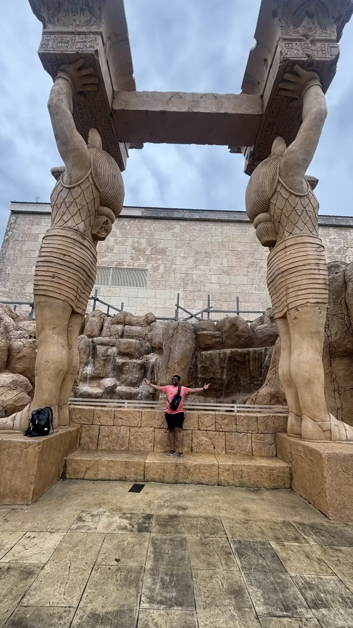 Manish standing between two towering Egyptian-style statues at Universal Studios Singapore