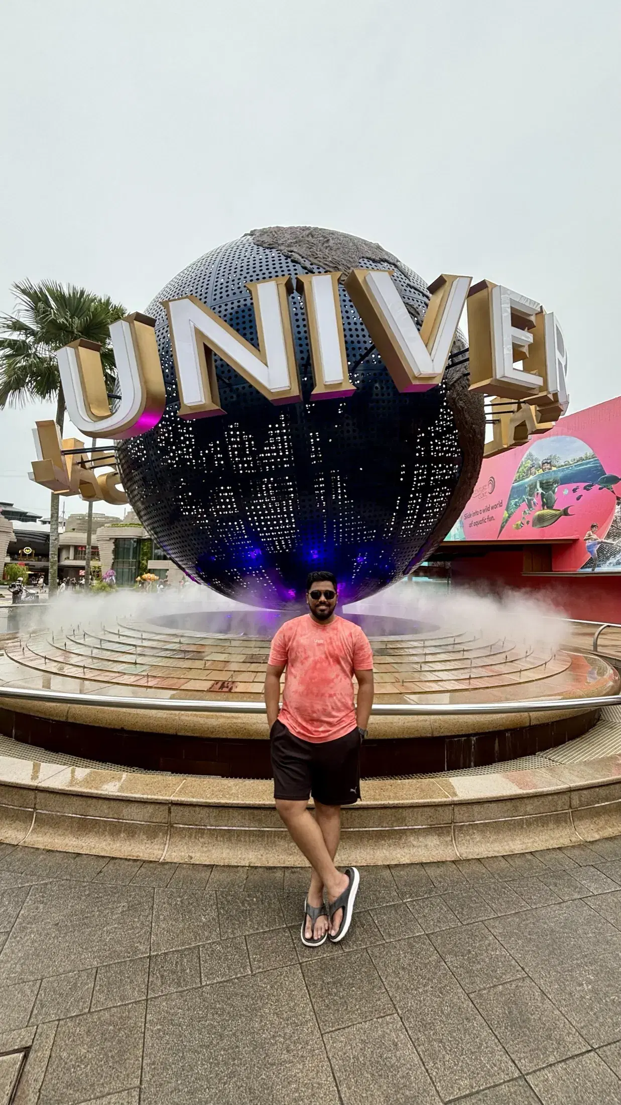 Manish standing in front of the Universal Studios globe on Sentosa